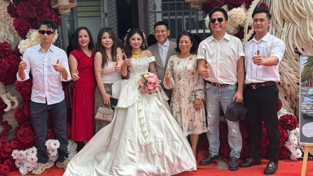 Hoài Lâm and bride Ngọc Trinh pose with guests at their wedding on the morning of October 6.