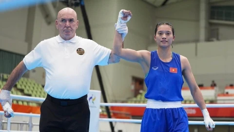 The referee raises Nguyễn Thị Tâm's hand after a boxing bout. Photo: LĐQAVN, via BongdaPlus.