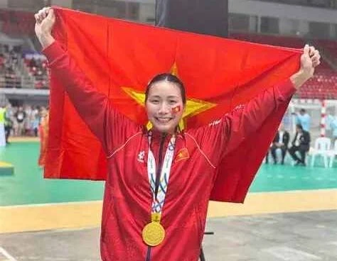 Ảnh tư liệu: Nguyễn Thị Ánh Tuyết khoác cờ đỏ sao vàng, đeo huy chương vàng trong nhà thi đấu