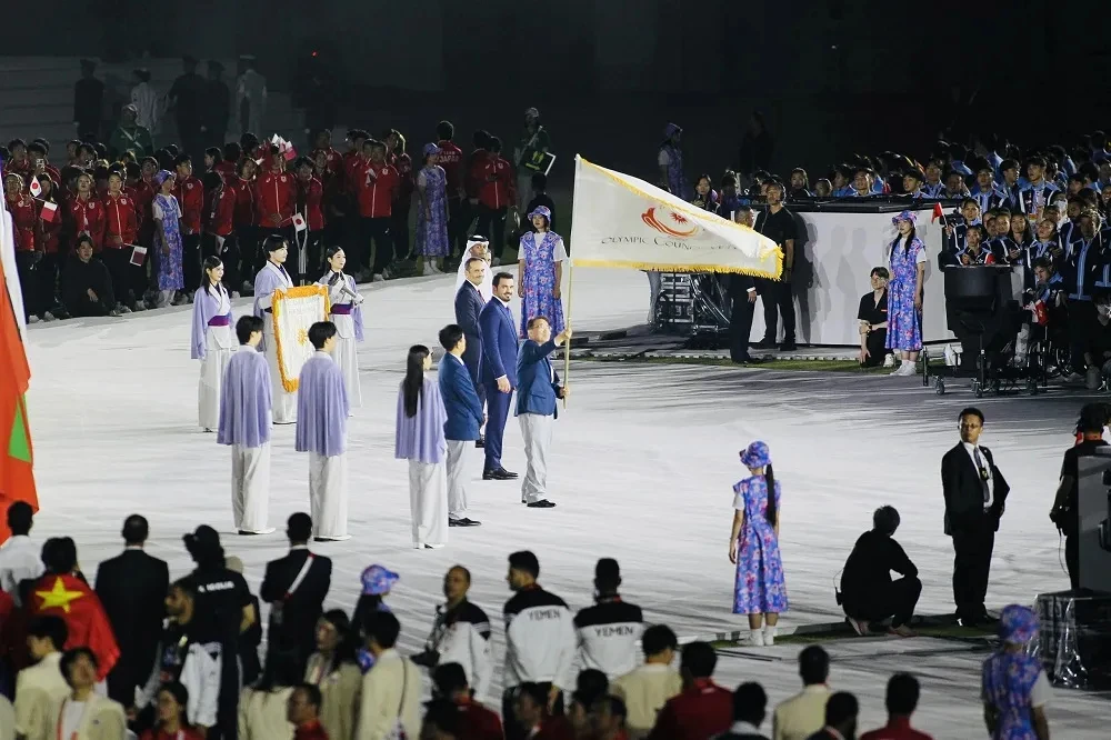 A flag handover during the closing ceremony of the 20th Asian Games; it does not depict the future 21st edition.