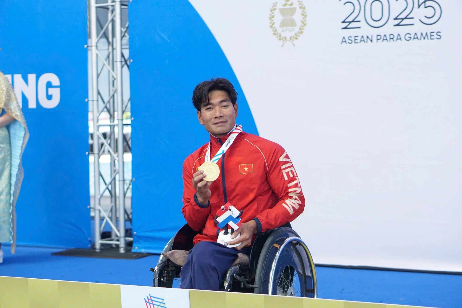 Kình ngư Đỗ Thanh Hải ngồi xe lăn, giơ cao tấm huy chương vàng Asian Para Games 5.