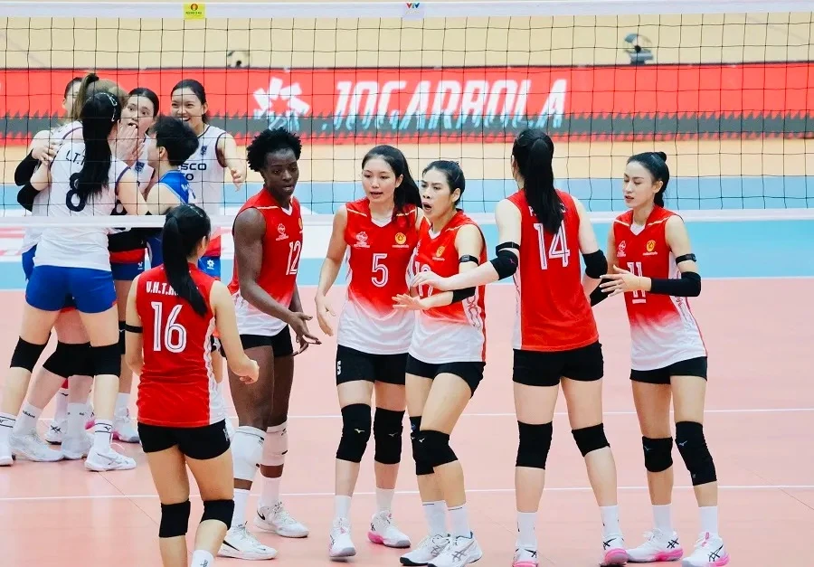 Women volleyball players on court during an indoor match.