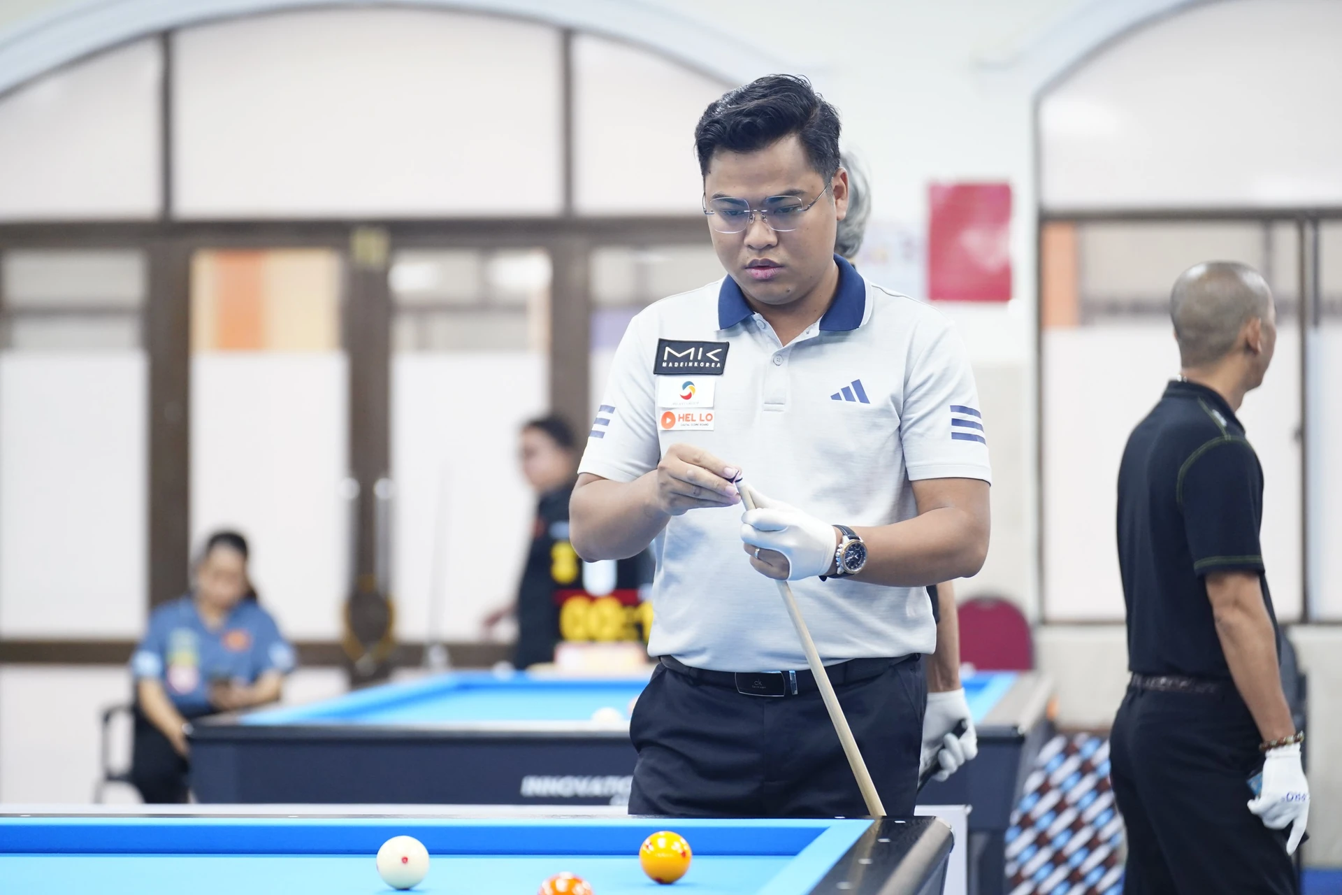 Cơ thủ Nguyễn Trần Thanh Tạo thoa phấn đầu cơ bên bàn billiards.