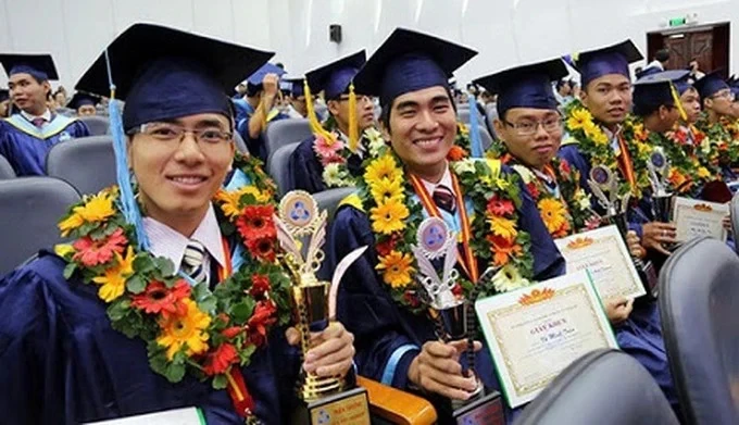 Ảnh tư liệu: Các tân cử nhân mặc lễ phục, cầm hoa và giấy khen tại một lễ tốt nghiệp