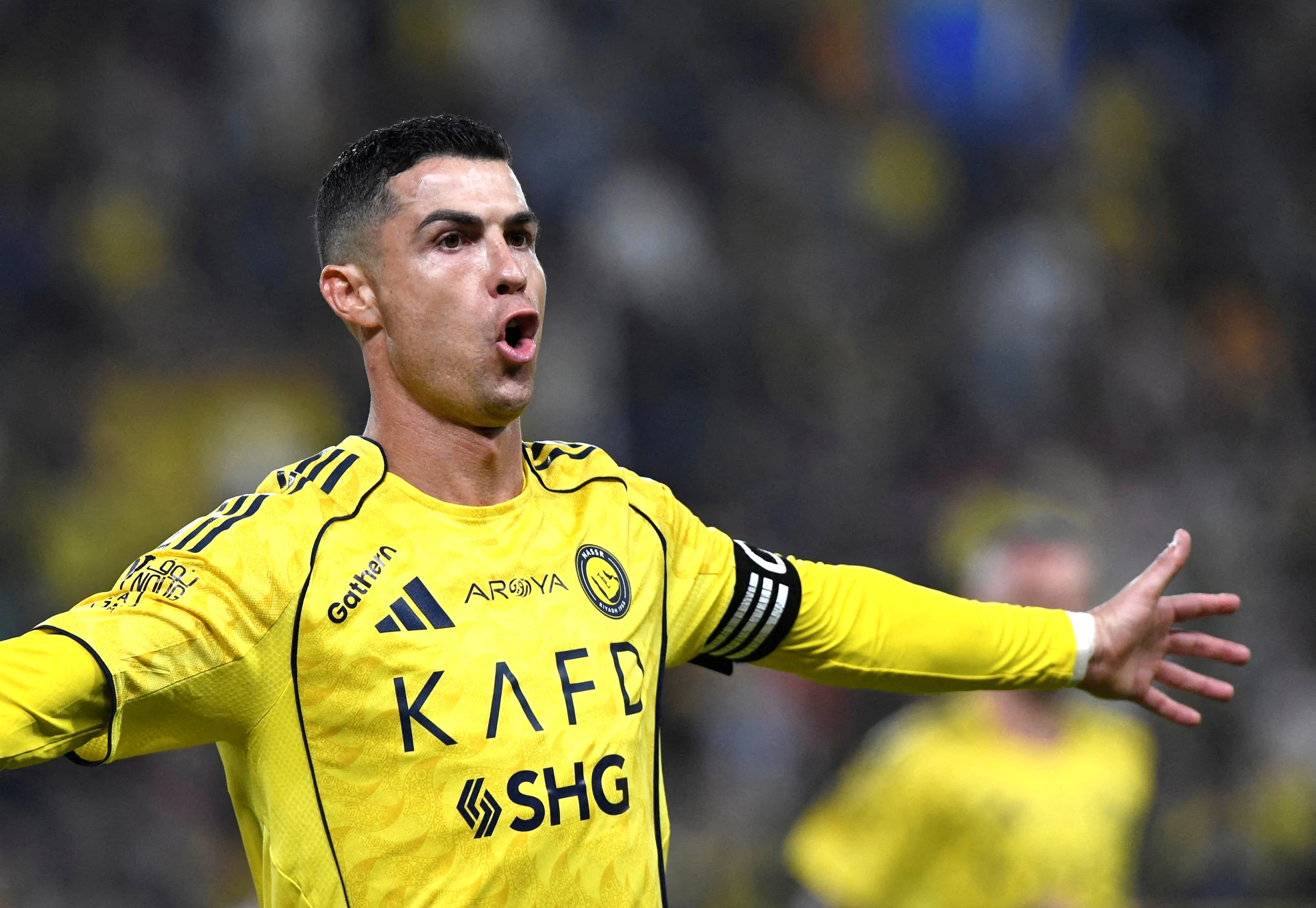 File photo: Cristiano Ronaldo in a yellow Al Nassr shirt and captain armband, arms spread wide and mouth open in celebration.