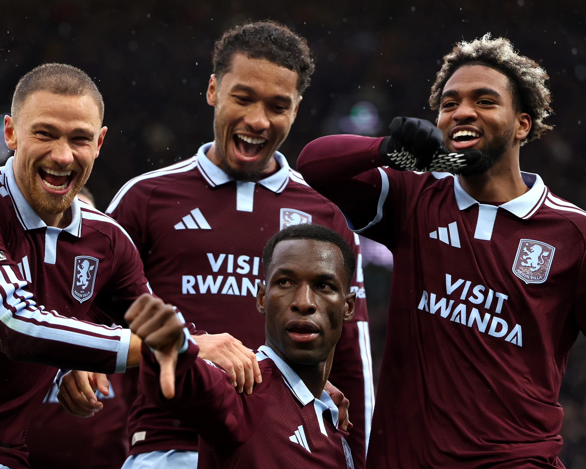Nicolas Jackson chỉ ngón cái xuống ăn mừng giữa vòng vây các đồng đội Aston Villa đang cười lớn