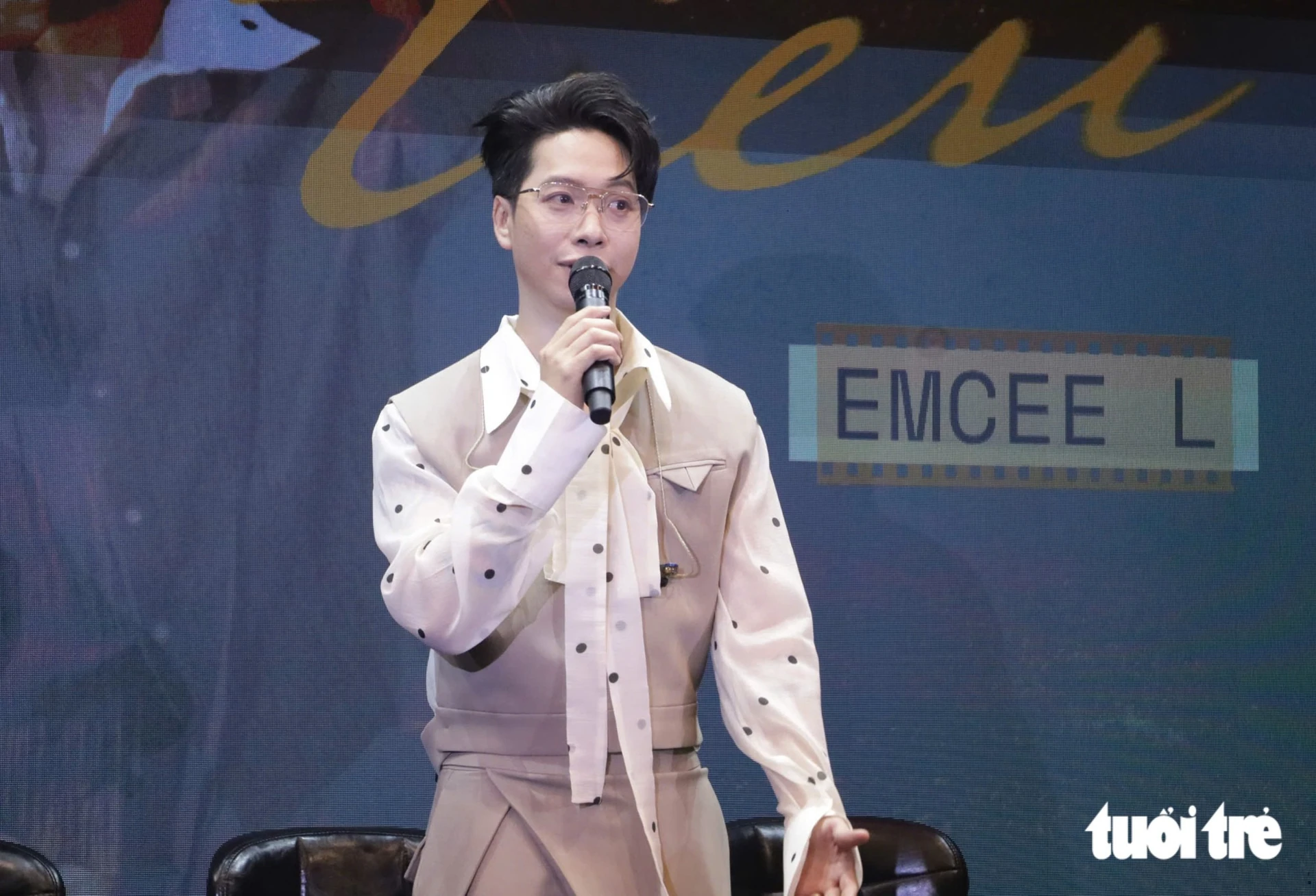 Emcee L cầm micro tại buổi họp báo giới thiệu album solo đầu tay.