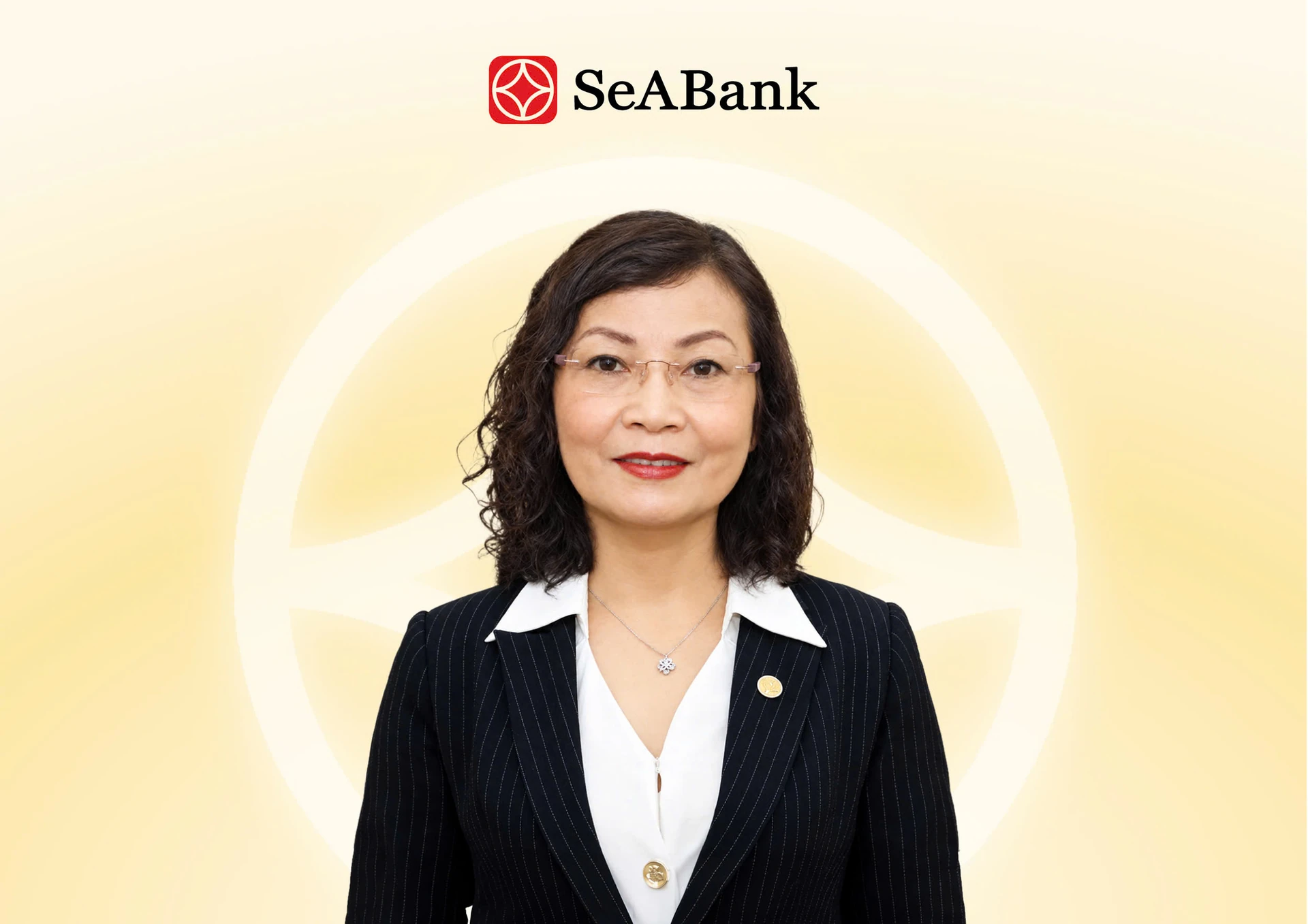 Chân dung bà Trần Thị Thanh Thủy, mặc vest đen, áo trắng, trên nền vàng nhạt có logo SeABank.