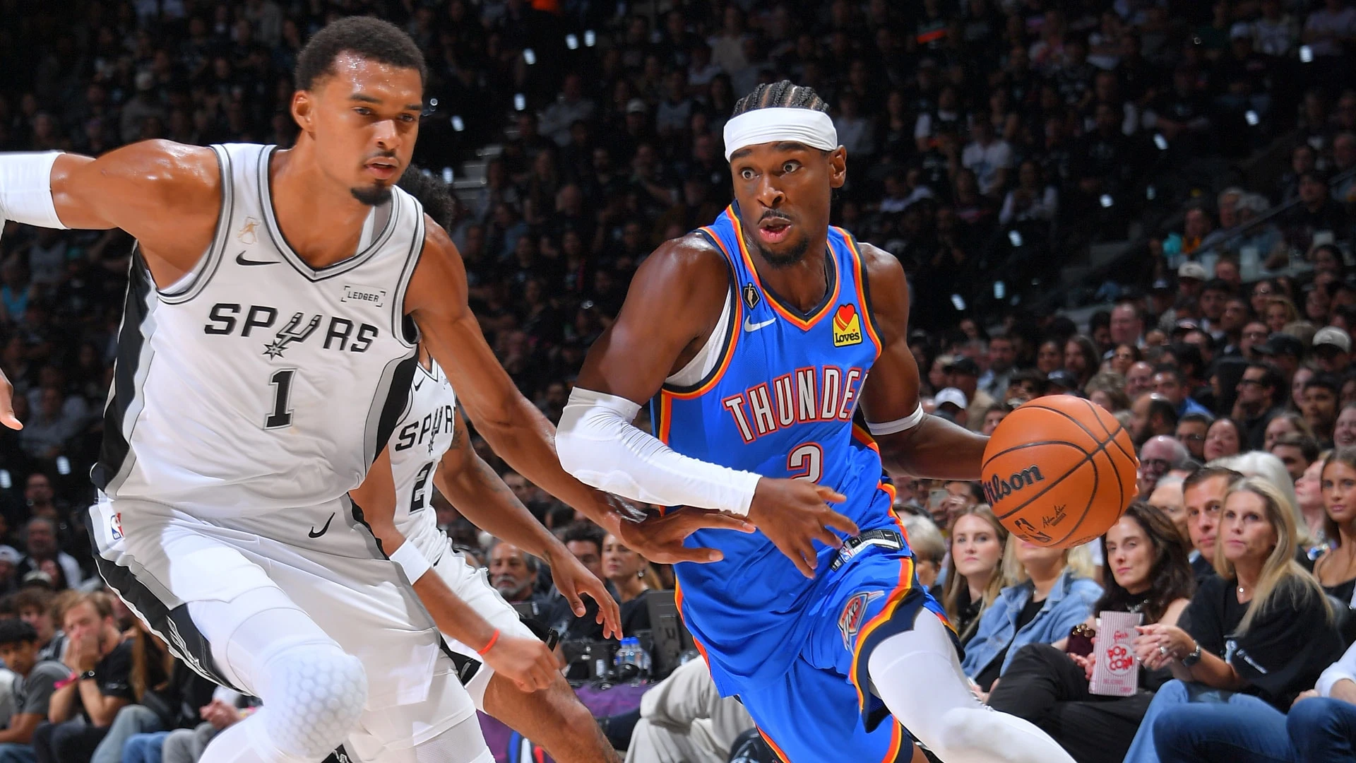 Shai Gilgeous-Alexander của Thunder đi bóng trước Victor Wembanyama của Spurs trong trận mở màn mùa NBA 2026-27.