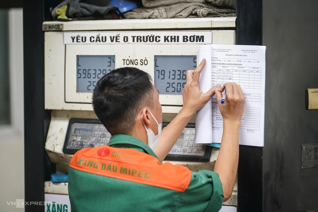 Nhân viên cập nhật bảng giá tại một cây xăng ở Hà Nội trong ảnh minh họa.