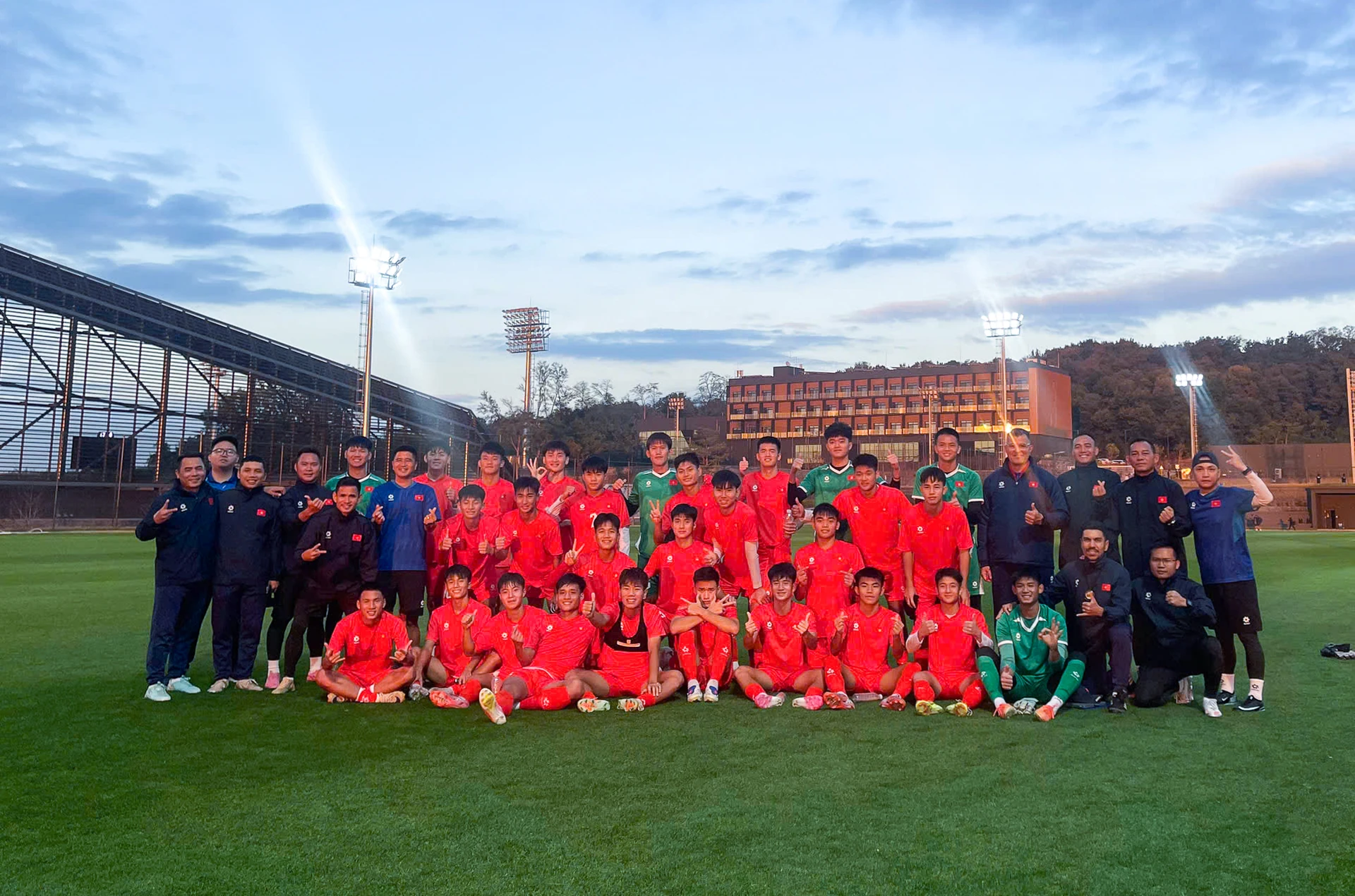Vietnam U17 players and staff pose for a group photo on a pitch in South Korea