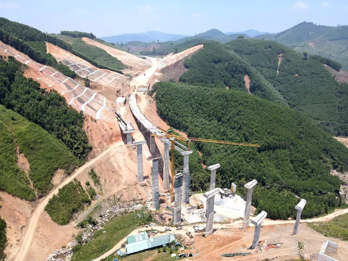 Expressway construction through hilly terrain, in a Báo Xây Dựng photograph.
