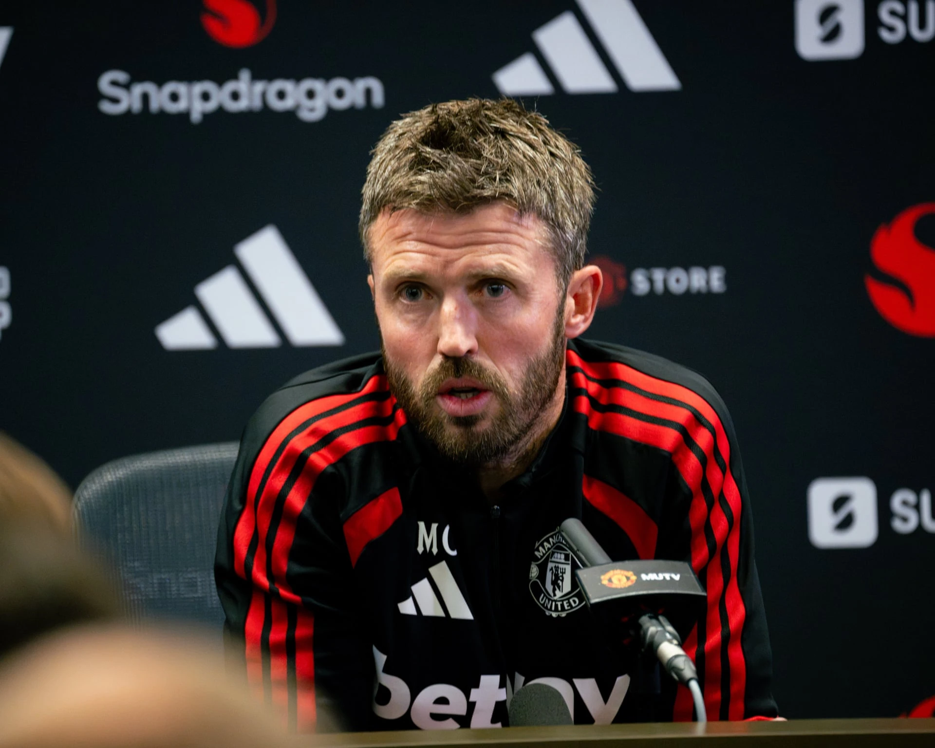 Ảnh tư liệu: ông Michael Carrick mặc áo tập Manchester United phát biểu trước micro MUTV tại buổi họp báo.