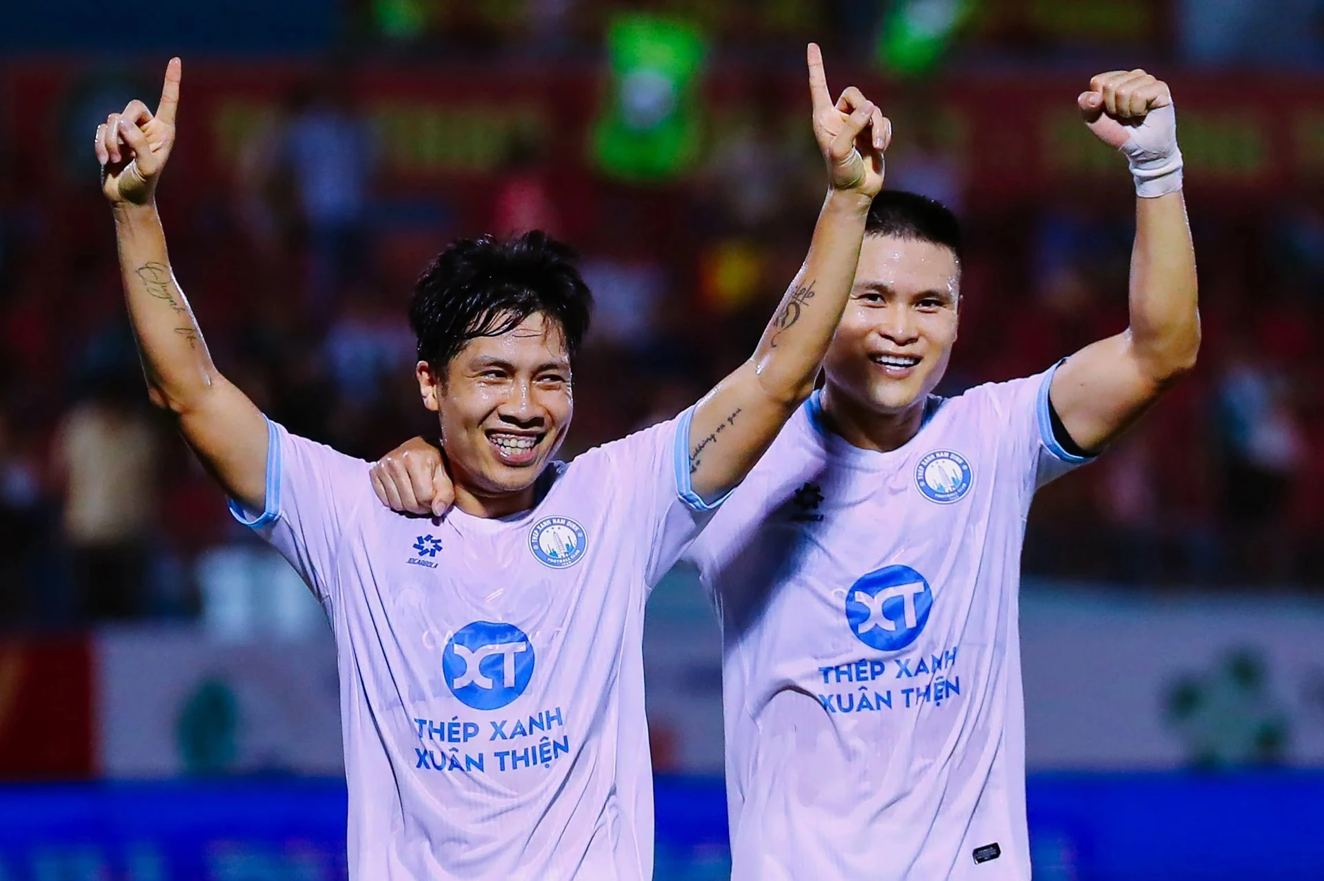 Văn Vĩ (left) celebrates scoring for Nam Định with a teammate