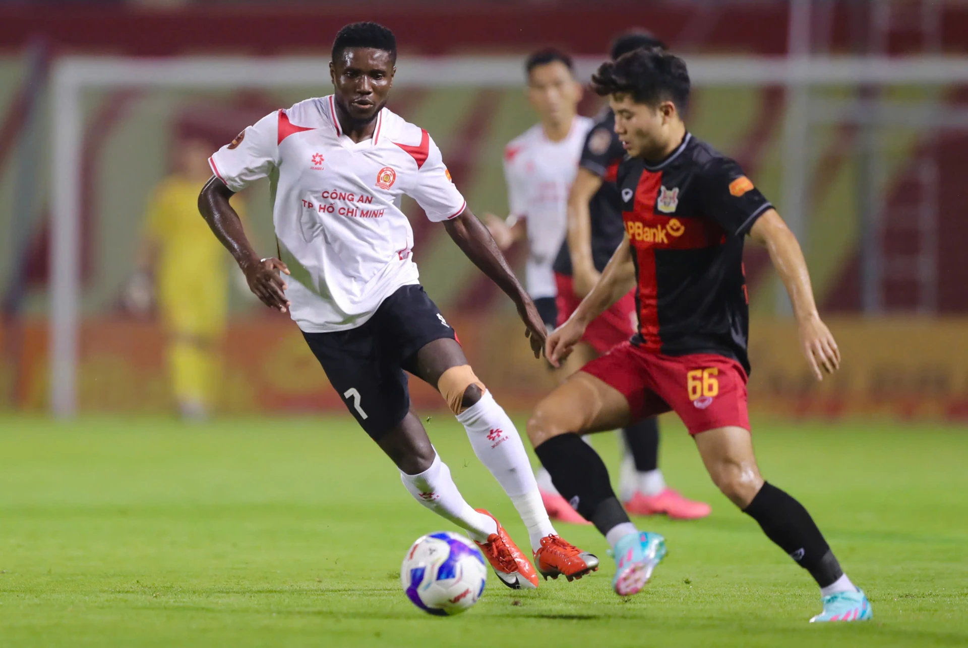 Olaha Mạnh Đức (left, in white) of Công an TP.HCM on the ball against Ninh Bình in round 5 of the 2026-27 V-League