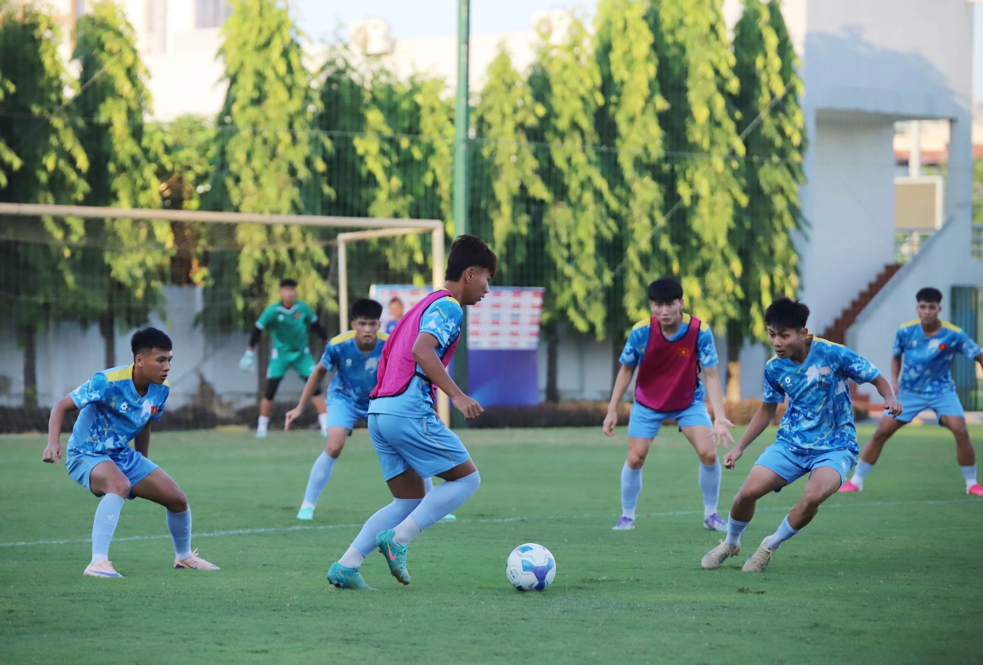 Các cầu thủ U17 Việt Nam trong trang phục tập xanh nhạt tranh bóng trong buổi tập trên sân cỏ