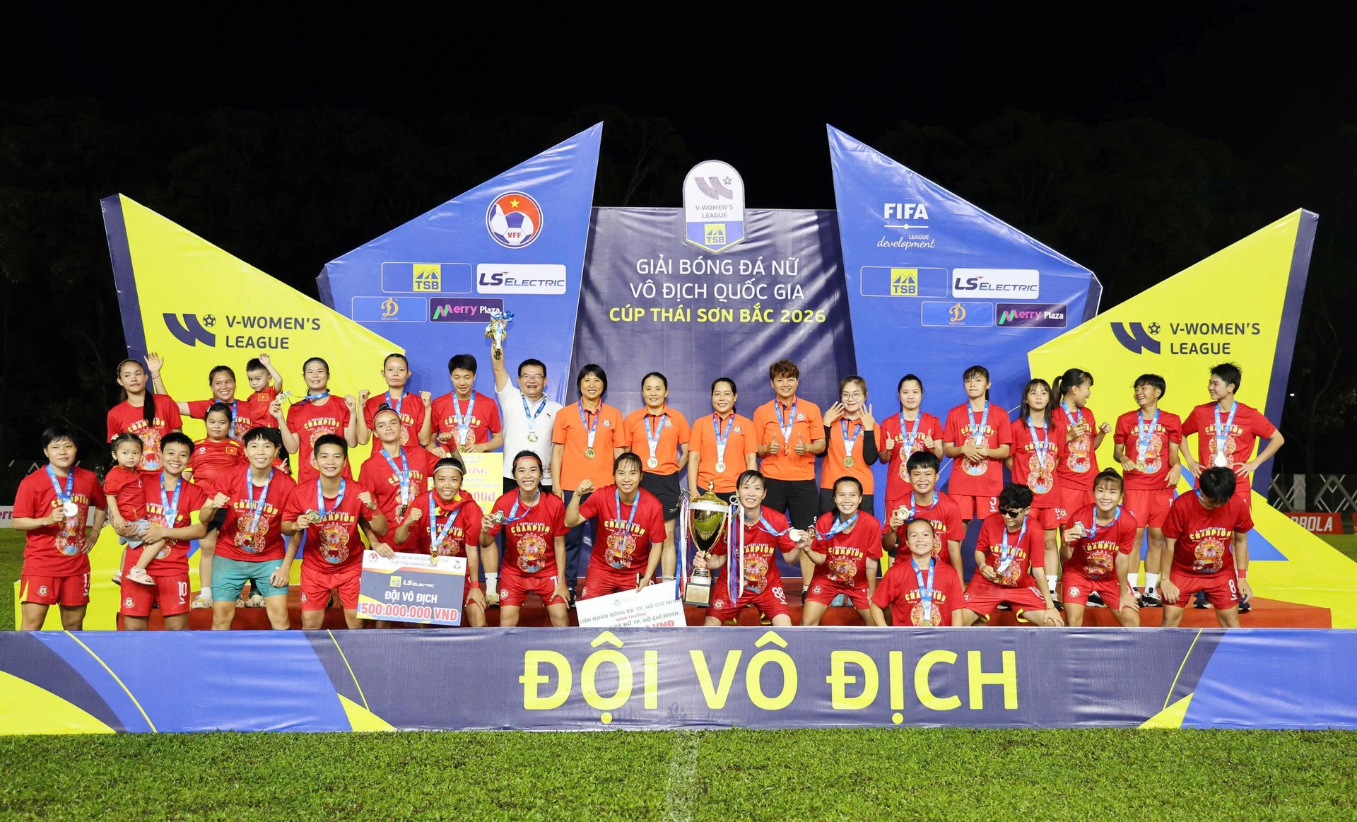 Ho Chi Minh City I women's players, in red with medals, pose with the 2026 Vietnam women's national championship trophy.