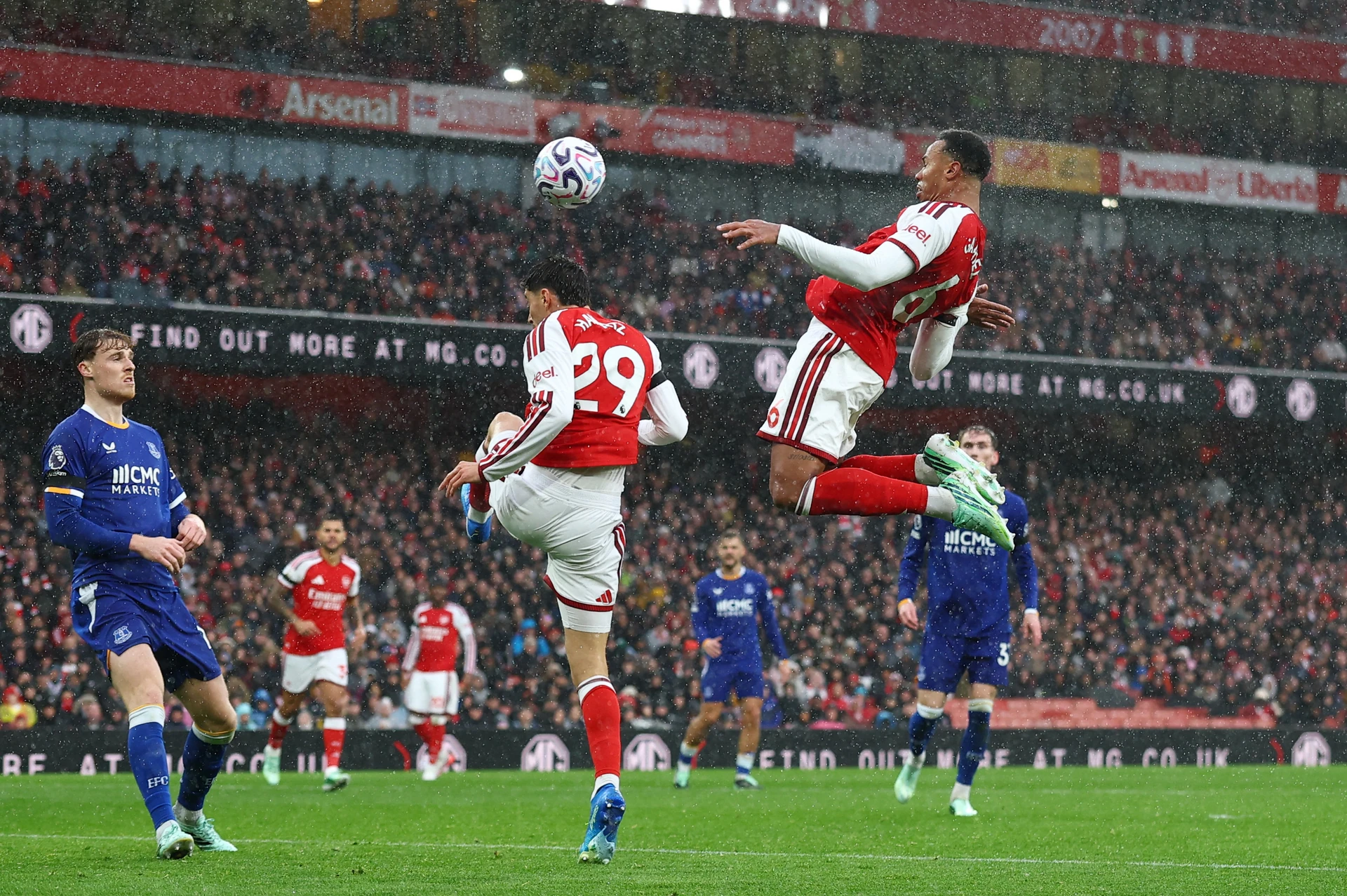Gabriel Magalhaes leaps to head the ball as Kai Havertz jumps in front of him and Everton players in blue look on at the Emirates
