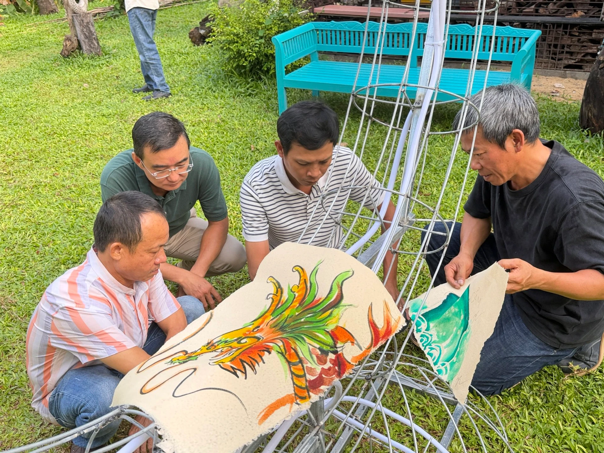Artist Đàm Đăng Lại and Hội An artists attach painted Washi paper panels to the steel frame of a Neputa lantern.