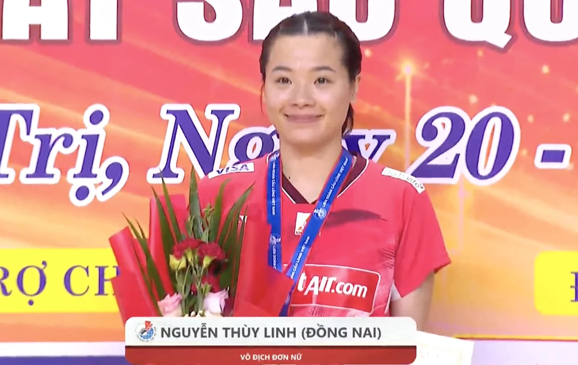 Nguyễn Thùy Linh (Đồng Nai) đeo huy chương, cầm hoa trên bục nhận giải vô địch đơn nữ tại Quảng Trị trưa 25/10/2026 (ảnh chụp màn hình)