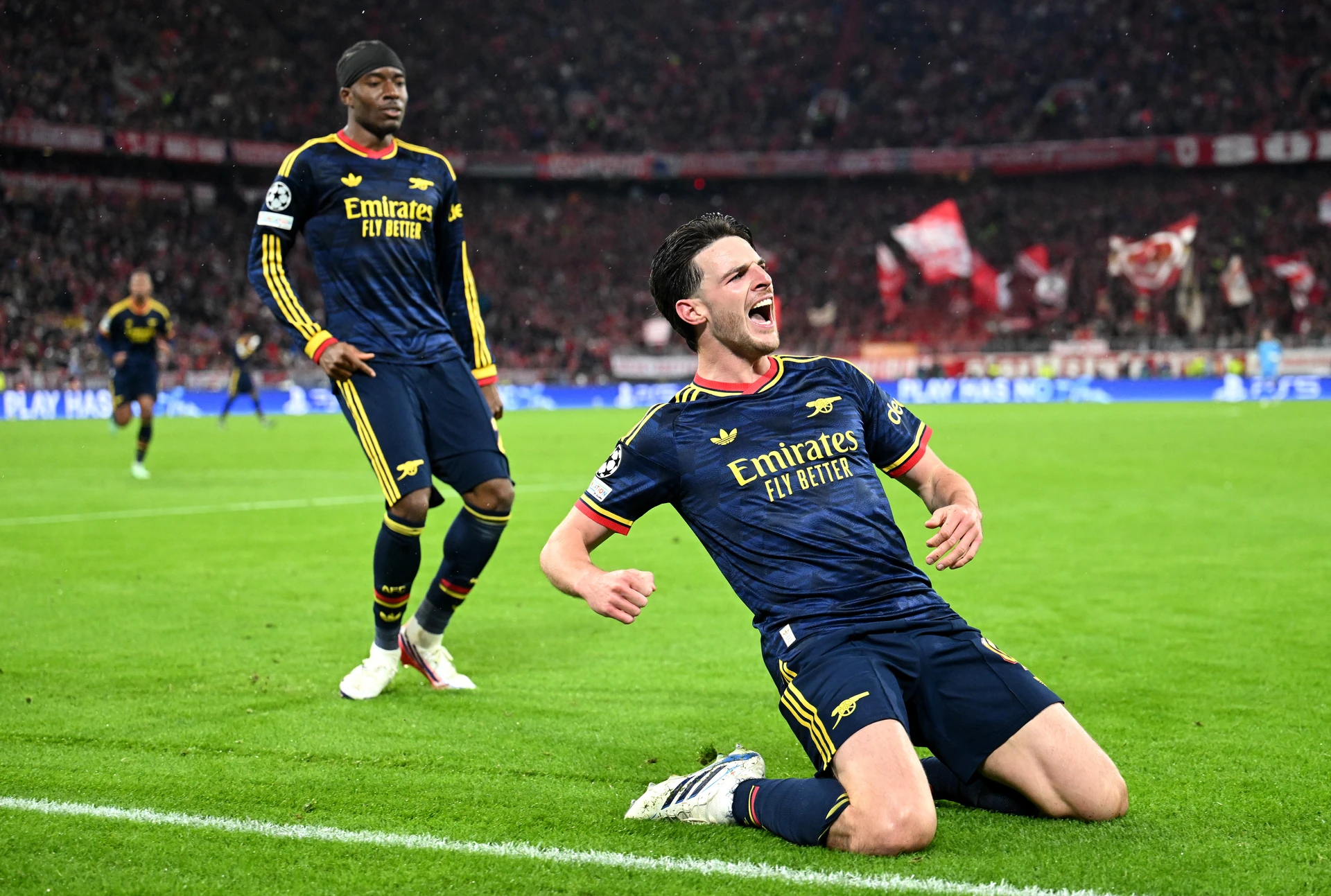 Declan Rice trượt gối ăn mừng sau khi ghi bàn gỡ hòa cho Arsenal ở cuối trận gặp Bayern Munich.