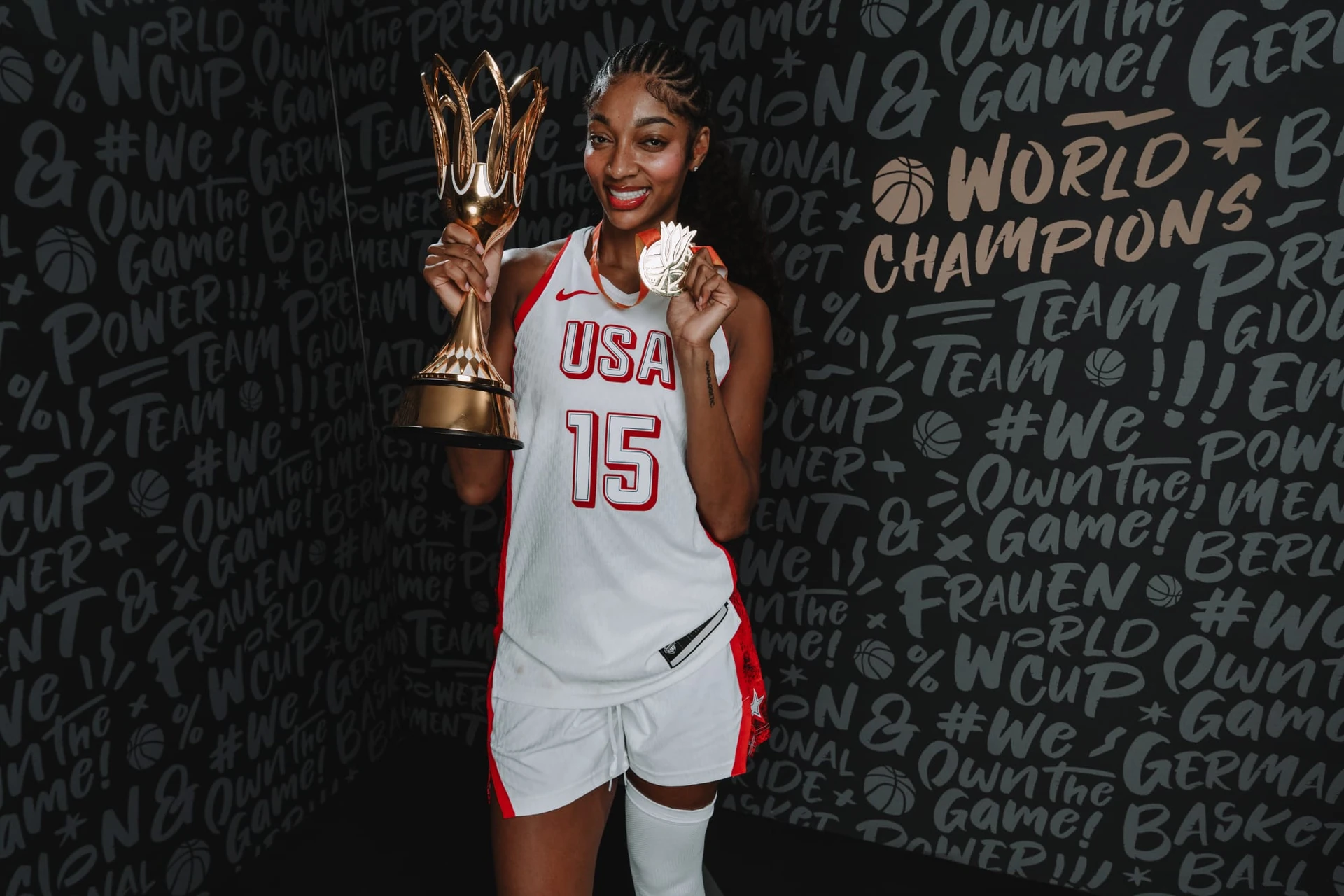 Một tuyển thủ Mỹ cùng cúp và huy chương trong ảnh FIBA dùng minh họa chung kết WNBA.