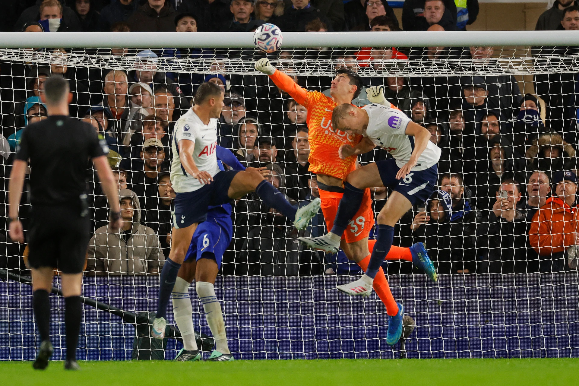 Chelsea goalkeeper Mike Penders (orange, No 39) punches at a corner under pressure from Jan Paul van Hecke; the ball went in off his glove to give Tottenham the lead at Stamford Bridge on 24 October 2026.