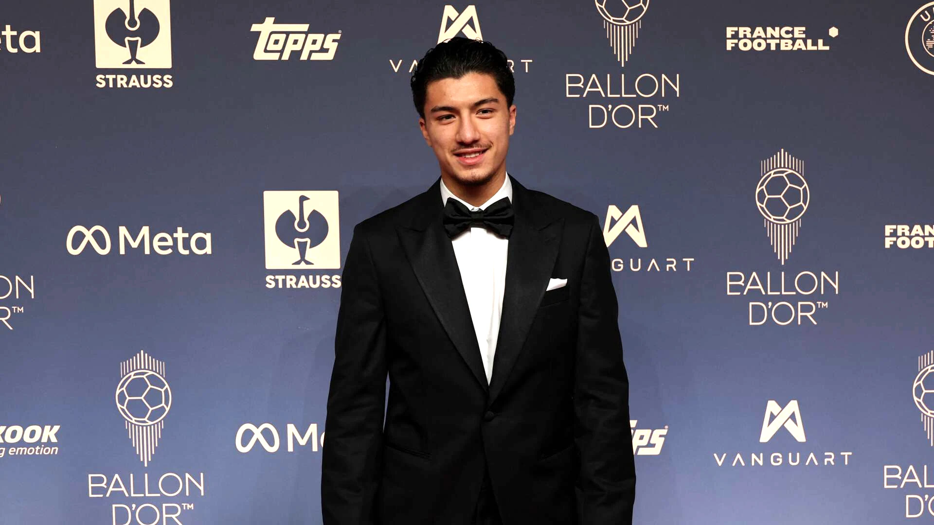 Ibrahim Maza mặc vest đen tạo dáng trên thảm đỏ lễ trao giải Quả bóng vàng 2026 tại London.