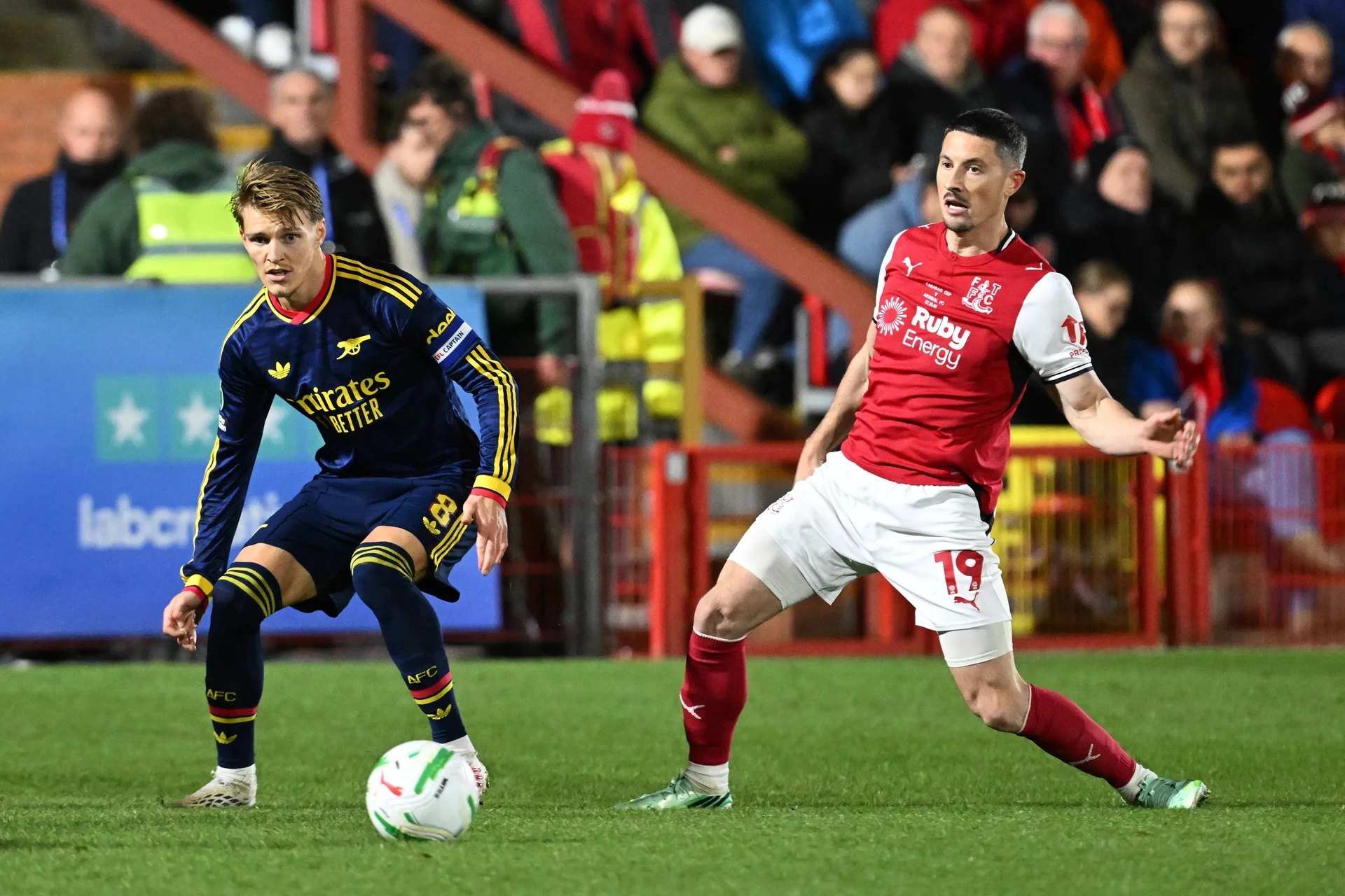 Martin Ødegaard của Arsenal (trái) đi bóng trước Ronan Coughlan của Fleetwood Town.