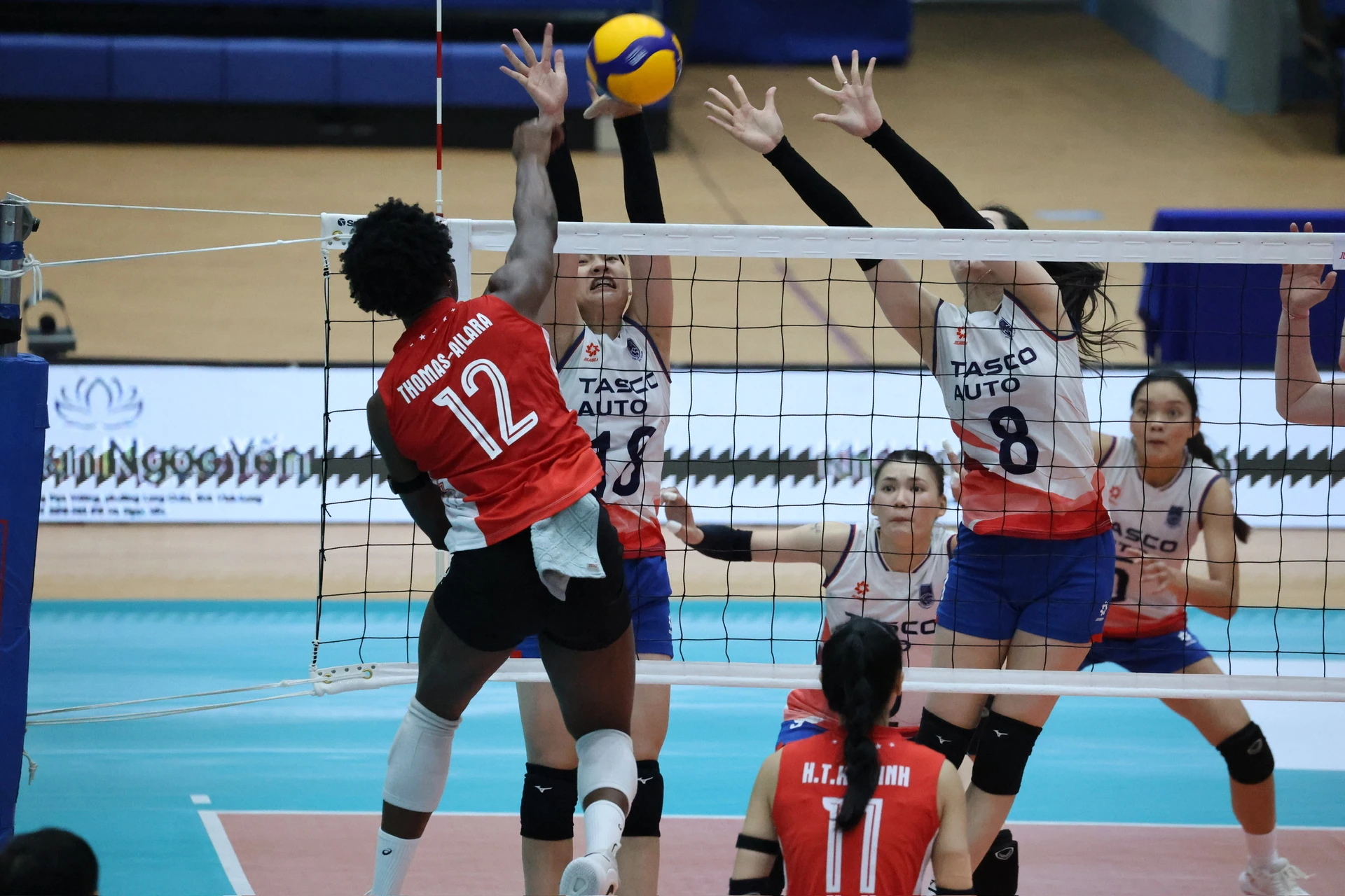 Binh chủng Thông tin players in red attack over the opposing block at the 2026 Vietnam women's volleyball championship.