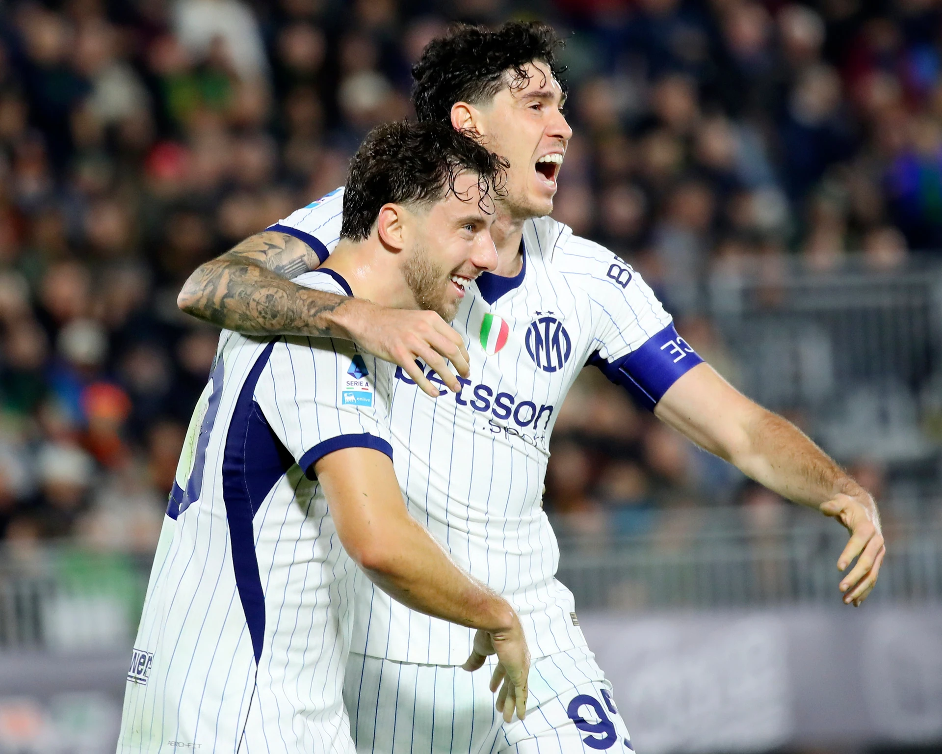 Inter's Carlos Augusto and Alessandro Bastoni celebrate after Redouane Halhal's late own goal at Venezia.