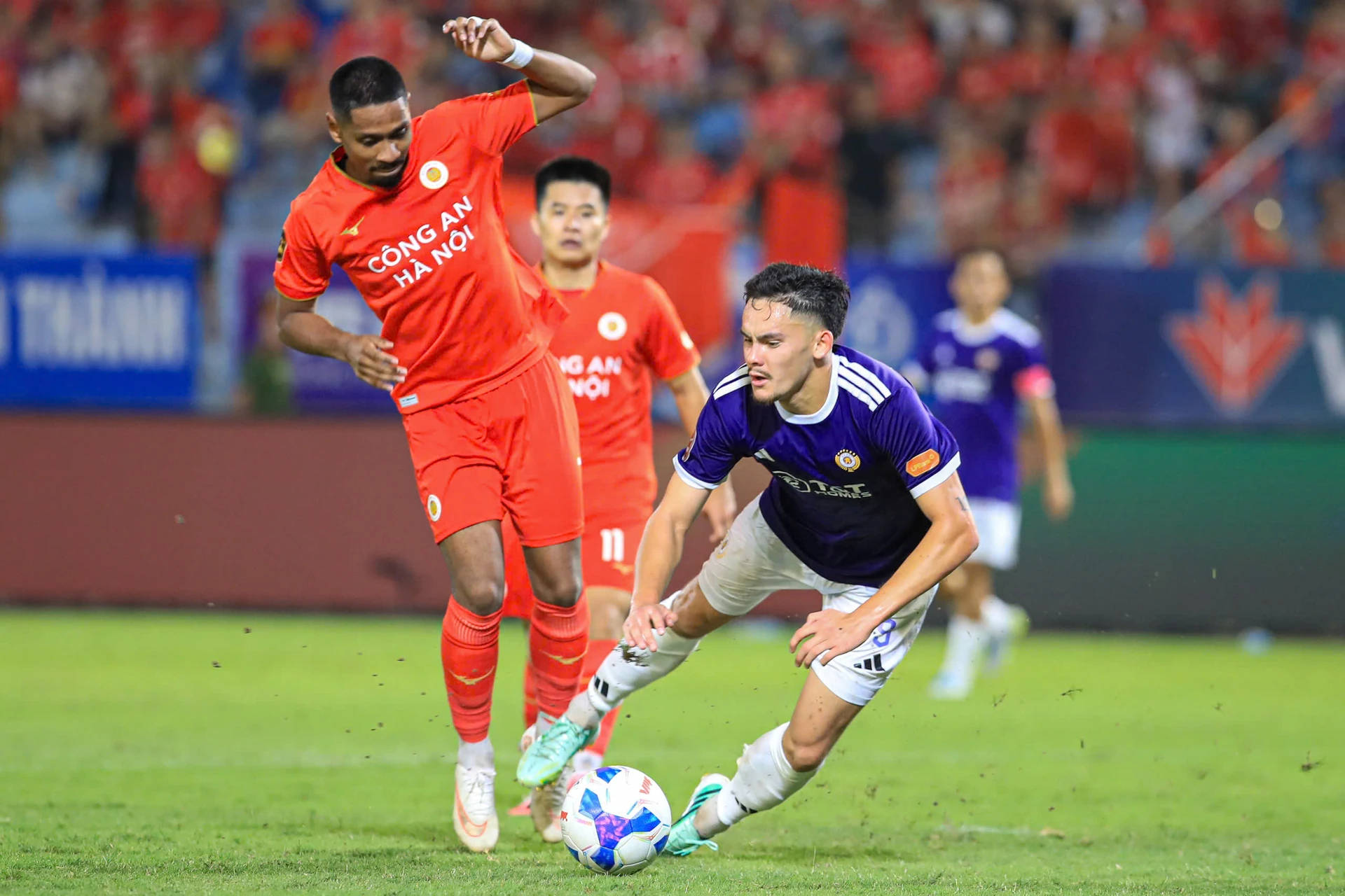 Công an Hà Nội player in red challenges a Hà Nội FC player in purple during a derby, file photo